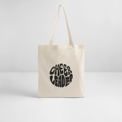 Tote Bag mit dem Aufdruck Cheerleader in rund und schwarz in der Farbe natural raw auf weißem Hintergrund.