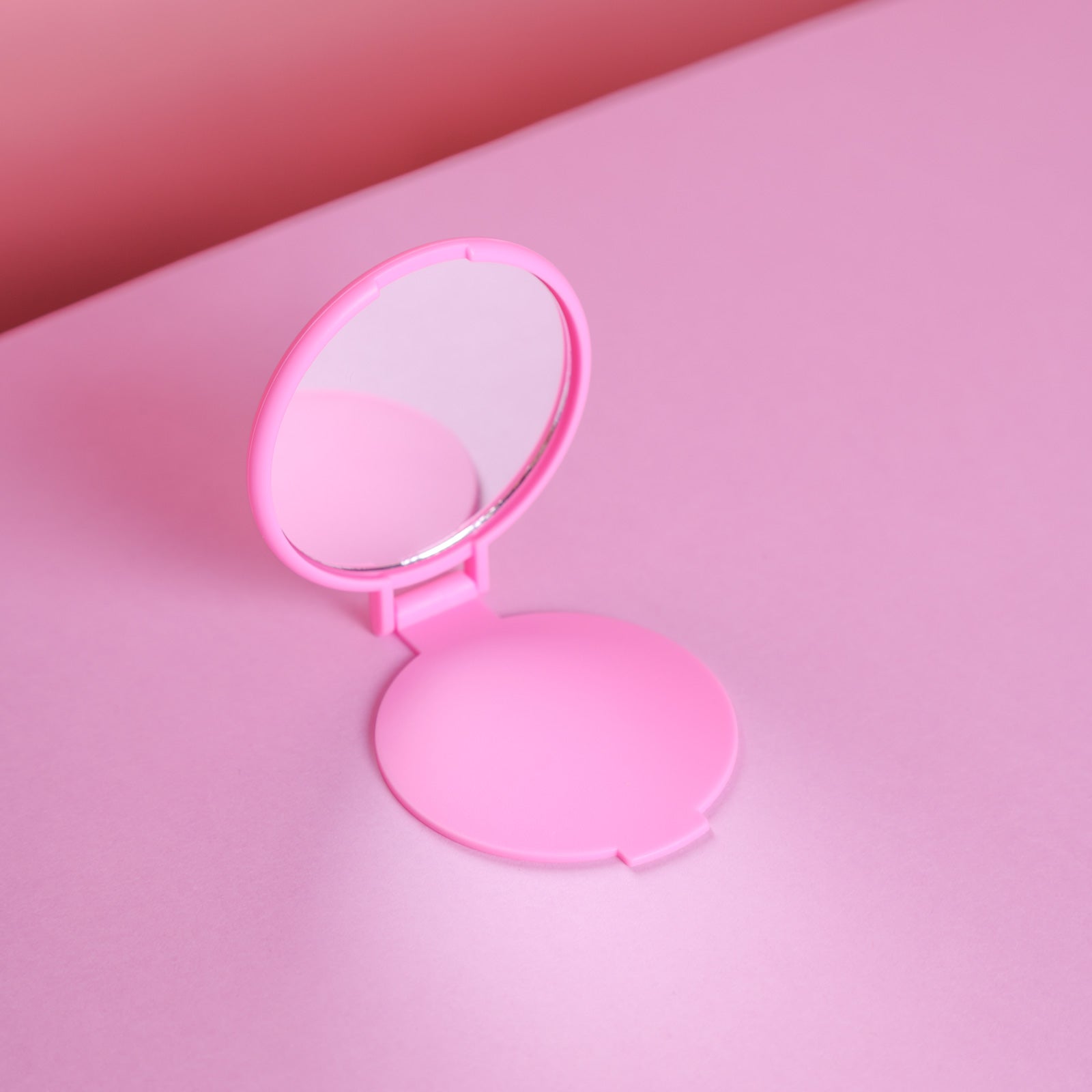 Cheerleader Handspiegel aufklappbar in Rosa zum Aufstellen auf rosafarbenem Hintergrund