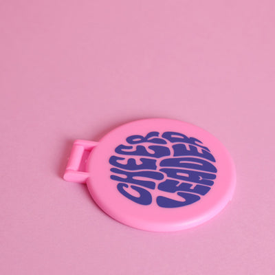 Cheerleader Handspiegel aufklappbar in Rosa zum Aufstellen auf rosafarbenem Hintergrund