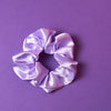 Ein lilafarbenes Scrunchie auf dunkel Lilanem Hintergrund. 