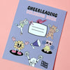 Cover des Malbuchs: Cheerleading Coloring Book. Auf dem Cover kann man seinen Namen eintragen. Es sind ausgemalte Cheerleading Motive aus dem Ausmalbuch auf dem Cover zu sehen. Unten rechts ist das Logo des Shops: Bow Bow. Das Buch mit lila hintergrund liegt auf einem rosafarbenem Papier.