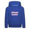 Kinder Hoodie mit Kapuze und Kangaroopocket.  Der Aufdurck ist: Cheerleader in lila,weiß, rosa Pixelschrif. Der Pullover ist royal blau.