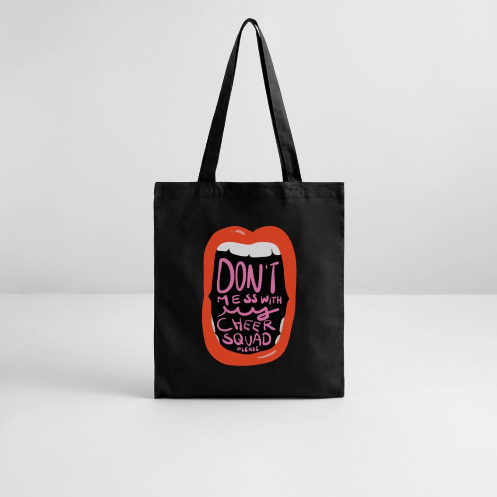 Tote-Bag mit dem Motiv: "Don't mess with my cheer squad" in schwarz auf weißem Untergrund und vor einer weißen Wand. Die Illustration zweigt einen Mund mit roten Lippen und weißen Zähnen in denen der Motivtitel in pinkt steht.