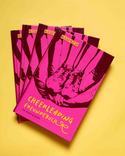 Cheerleading Freundebuch für Juniors und Seniors. 4 Bücher liegen über einander aufgefächert auf gelbem Hintergrund.