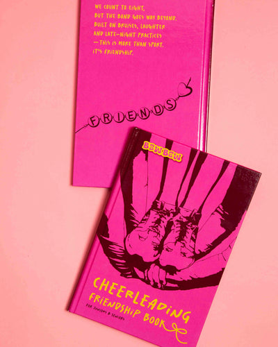 CHEERLEADING FRIENDSHIP BOOK: for Juniors & Seniors. Two Books lay on pink background. One shows the Cover and one the front.