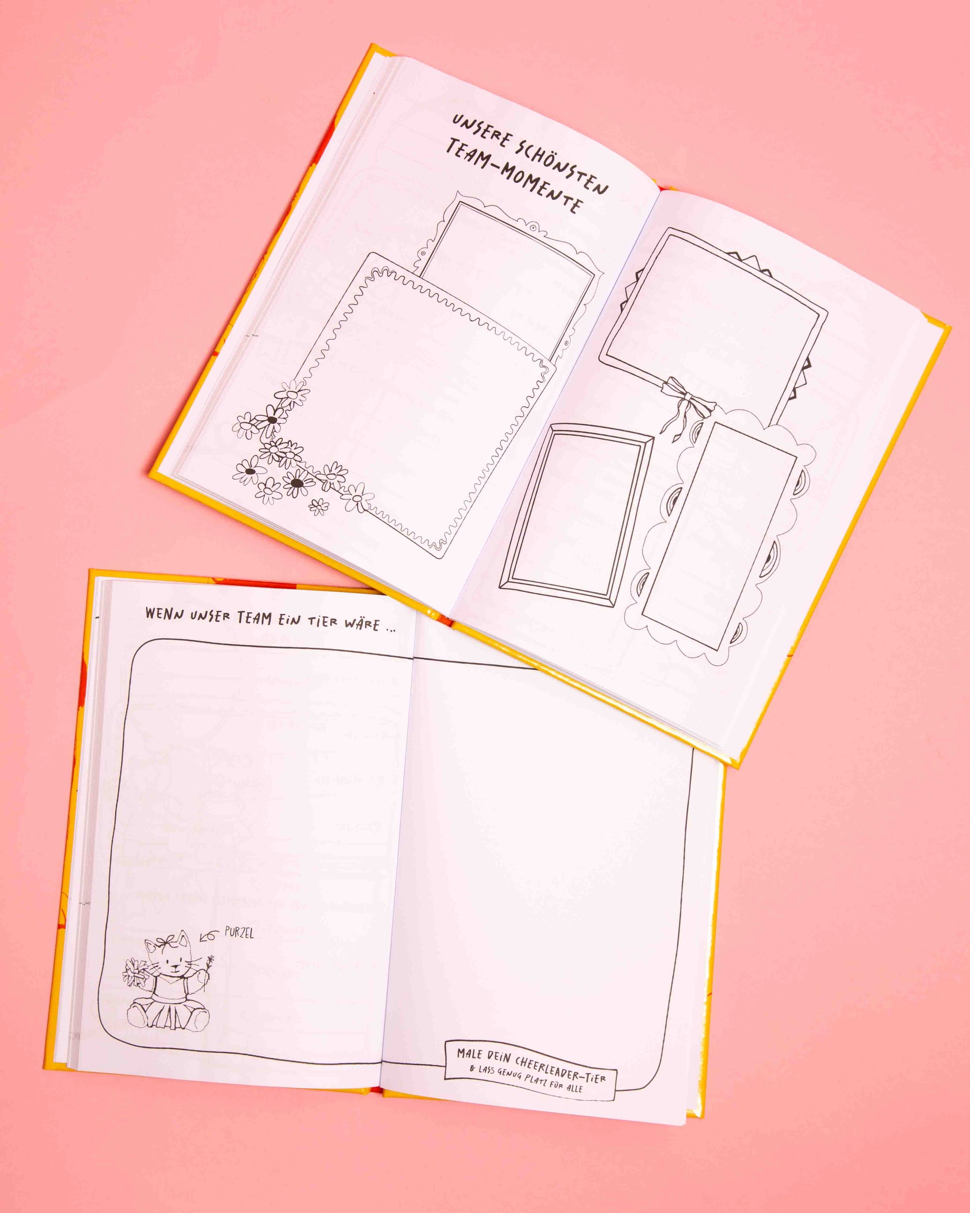 Zwei aufgeschlagene Bücher des Cheerleader Freundebuches für Peewees liegen auf rosafarbenem Papierhintergrund und zeigen die Seiten: "Unsere schönsten Team-Momente "und "Wenn unser Team ein Tier wäre..."